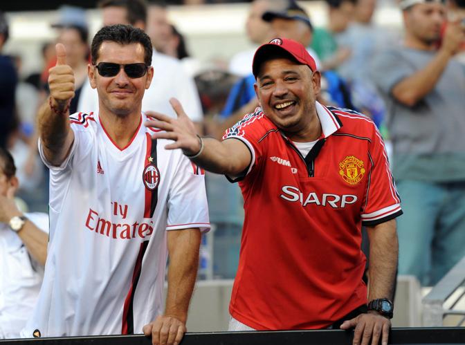 Un tifoso con la maglia rossonera accanto ad un simpatizzante del Manchester United. Reuters